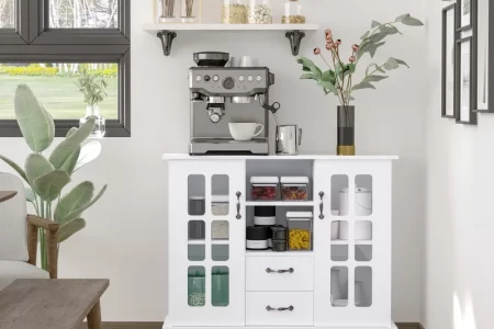 Buffet cabinet under art prints, styled with greenery, books, candle, and soft-toned personalized decor.