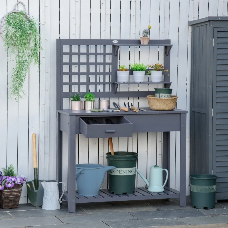 Gray potting bench with shelves, plants, and gardening tools.
