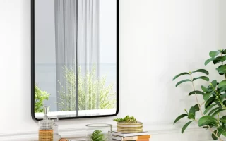 Wall-mounted rectangular mirror above a dresser with books and décor.