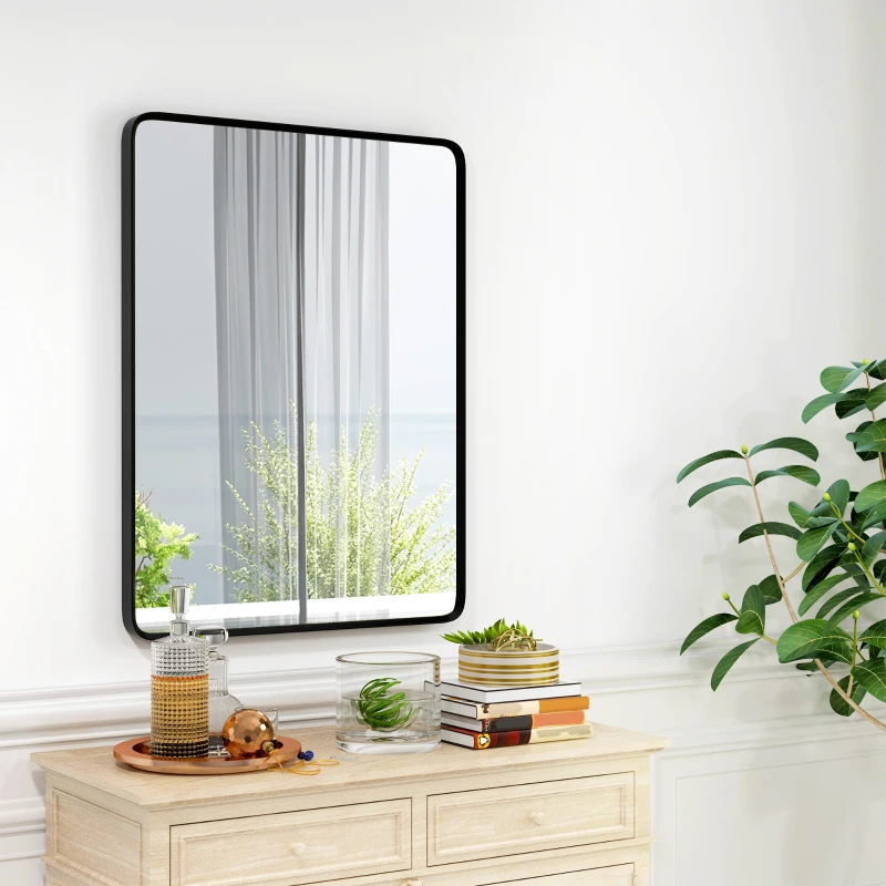 Wall-mounted rectangular mirror above a dresser with books and décor.