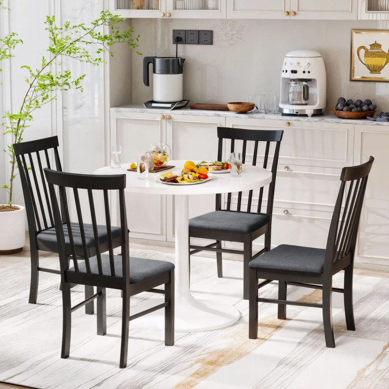 Black dining chairs around a white round table.