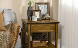 Wooden end table styled with decor, books, and framed photos.