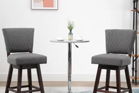 Two grey upholstered bar stools paired with a modern round table.