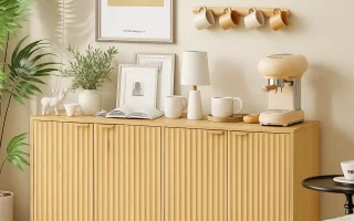 Sideboard decorated with coffee machine, mugs, lamp, and greenery.