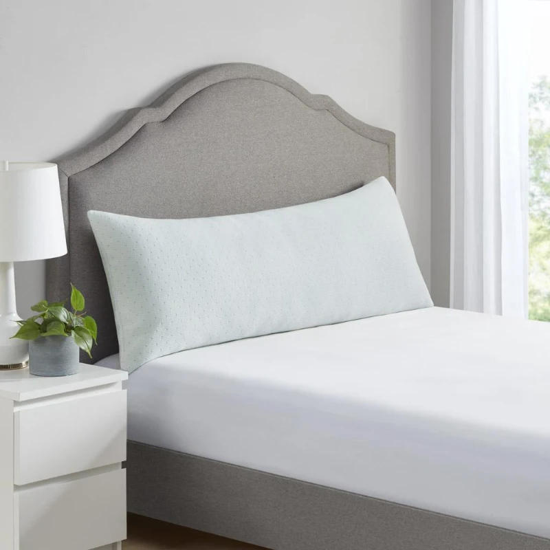 Long memory foam pillow placed on bed near headboard.