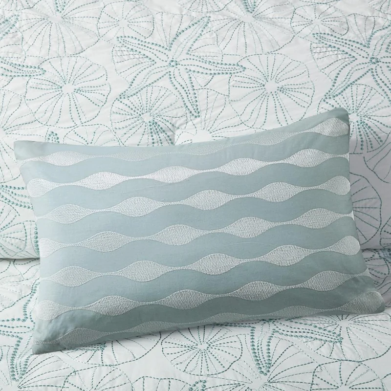 Light blue wavy patterned pillow on seashell bedding
