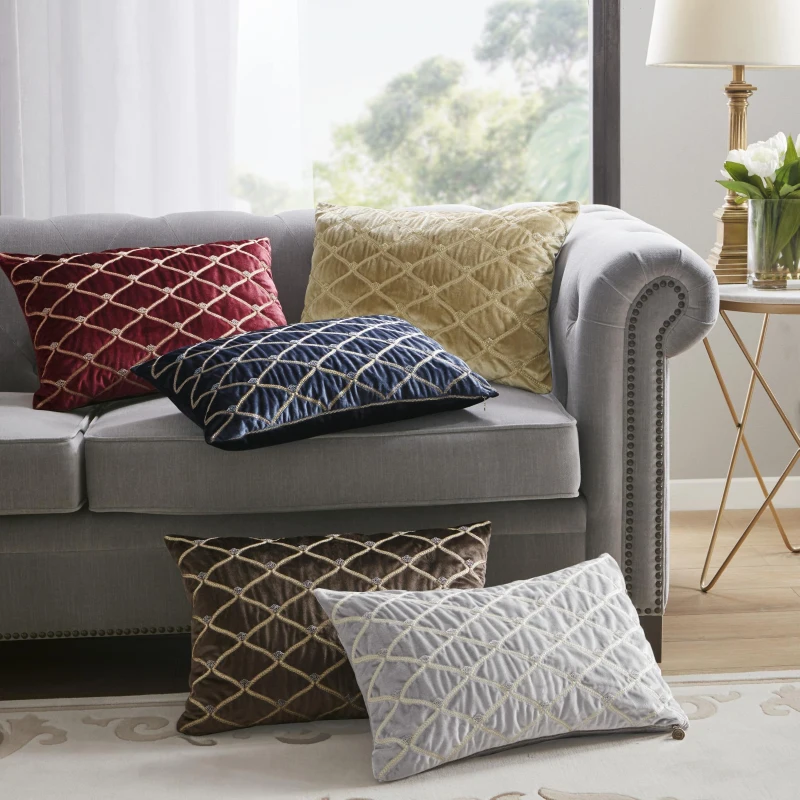 Colorful diamond quilted throw pillows on grey sofa
