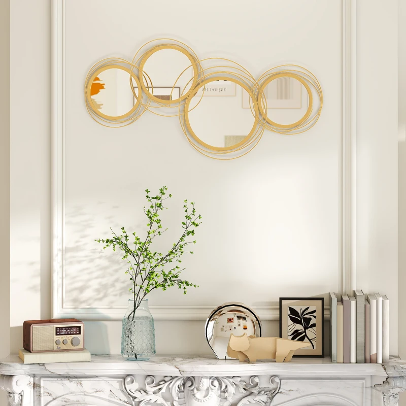 Decorative gold circular mirrors above mantel with books and decor.
