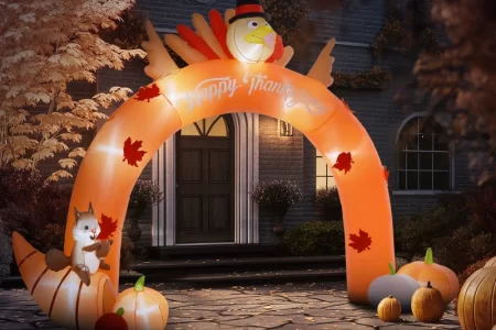 Inflatable turkey arch with pumpkins and squirrel in autumn yard.