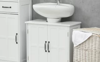 White bathroom vanity with a sink, storage cabinet, and laundry basket on a striped rug.