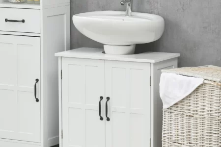 White bathroom vanity with a sink, storage cabinet, and laundry basket on a striped rug.