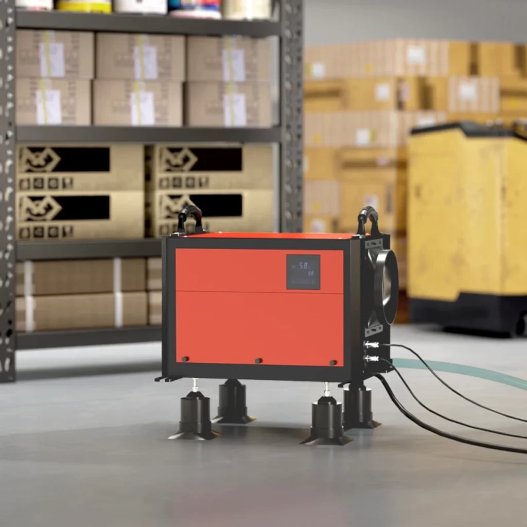 Red industrial dehumidifier in warehouse with drainage hoses