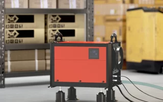 Red industrial dehumidifier in warehouse with drainage hoses