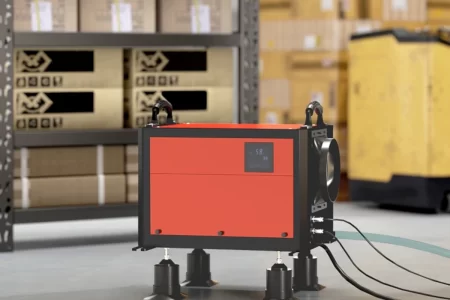 Red industrial dehumidifier in warehouse with drainage hoses