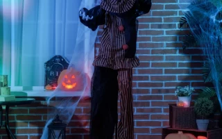 Scary clown prop with glowing eyes and cobweb decorations.