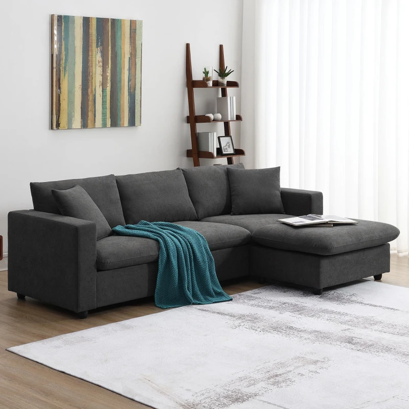 Modern dark grey L-shaped sofa with teal throw blanket.