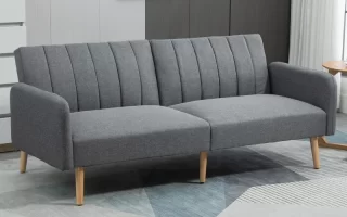 Modern grey fabric sofa with wooden legs in a minimalist living room.