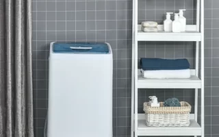 Compact washing machine placed beside storage cabinet and laundry basket