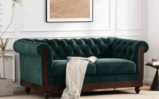 Green velvet sofa in modern living room with wall art.