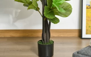 Tall faux tree in black nursery pot beside wall and framed art on wooden floor.