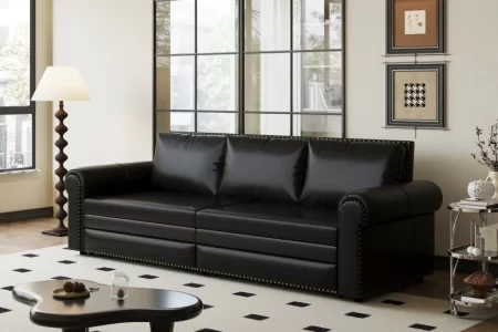 Black leather sofa in modern living room with rug.