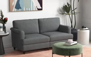 Modern grey sofa in living room with round ottoman