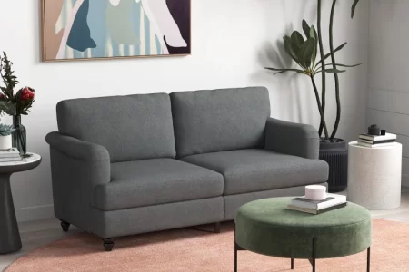 Modern grey sofa in living room with round ottoman