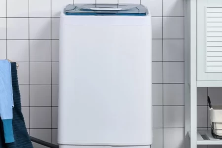 Portable washing machine in laundry area of a house.