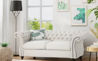 Beige tufted loveseat sofa styled in modern living room.