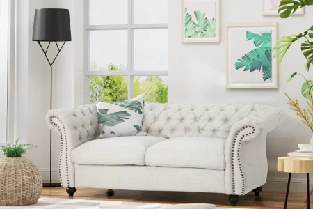 Beige tufted loveseat sofa styled in modern living room.