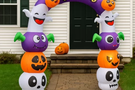 Inflatable Halloween archway with pumpkins, bats, and ghosts outside house.