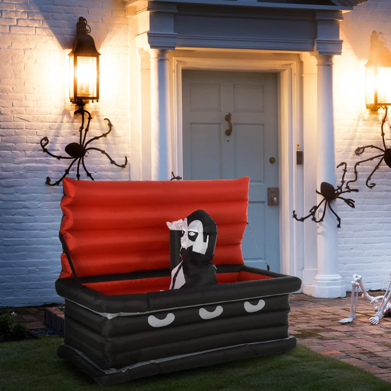 Inflatable vampire in coffin placed outside front door decorated with Halloween spiders and lanterns.
