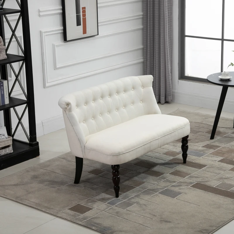 White tufted loveseat with wooden legs in a compact modern living area.