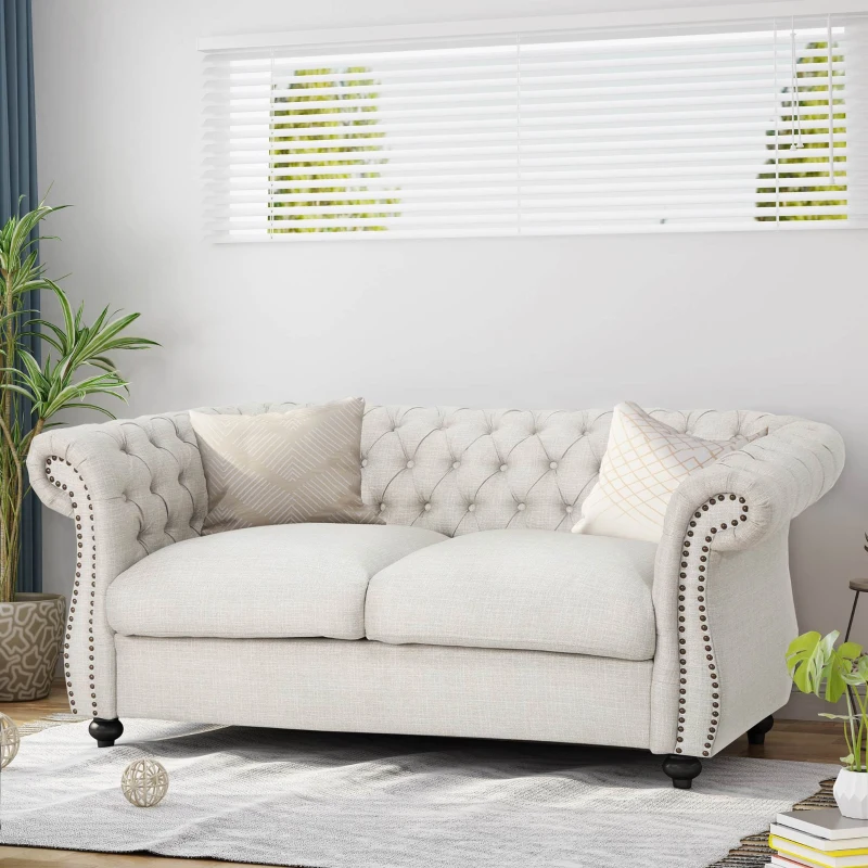 Beige tufted chesterfield sofa with plush cushions and nailhead detail.