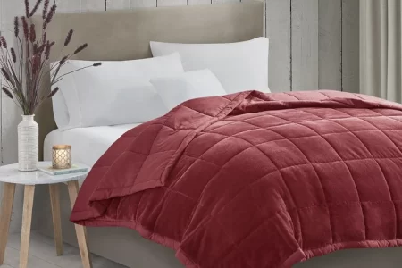 Cozy, styled bed with layered blankets enhancing room ambiance and visual appeal.