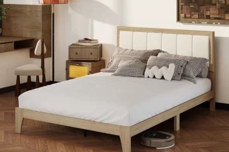 Modern wooden bed with white mattress in a cozy bedroom setting.