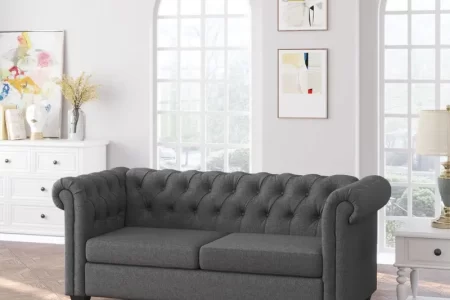 Dark grey tufted loveseat sofa in bright living room