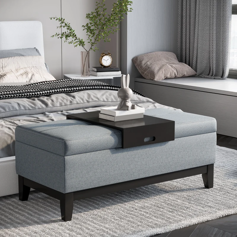 Light blue upholstered storage bench at bed end with tray.
