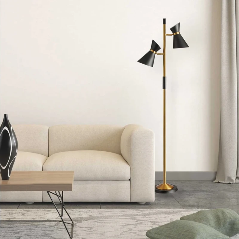 Gold floor lamp with two black cone shades beside sofa