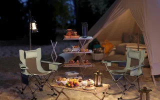 Camping chairs arranged near tent with lanterns and food setup