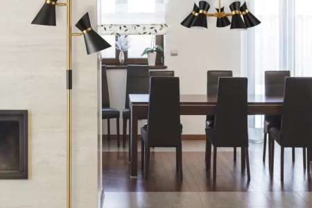 Gold and black floor lamp next to dining table and chairs