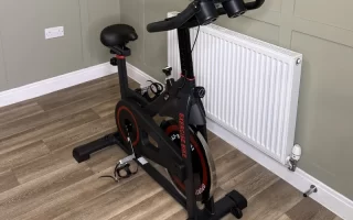 Indoor exercise bike with black frame and red detailing in modern home gym