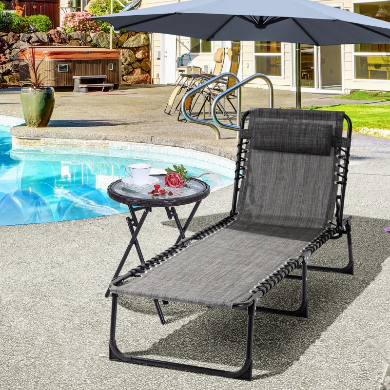 Poolside black lounge chair with side table under umbrella