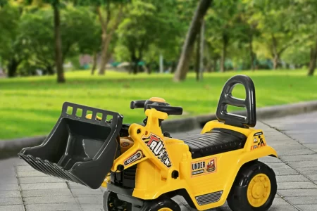 Yellow kids ride-on digger toy with front loader in park