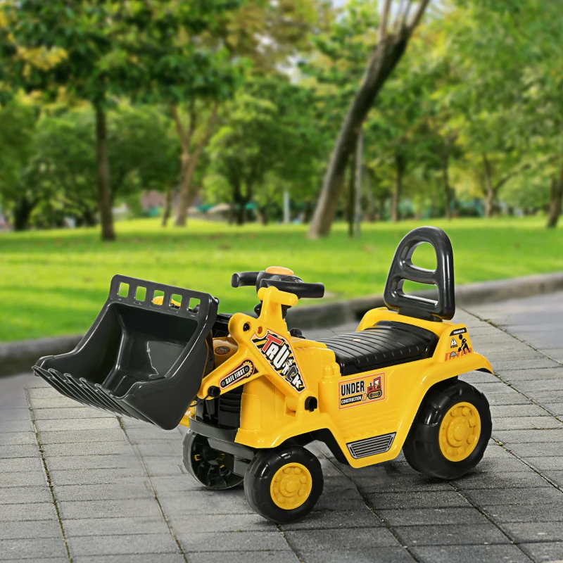 Yellow kids ride-on digger toy with front loader in park
