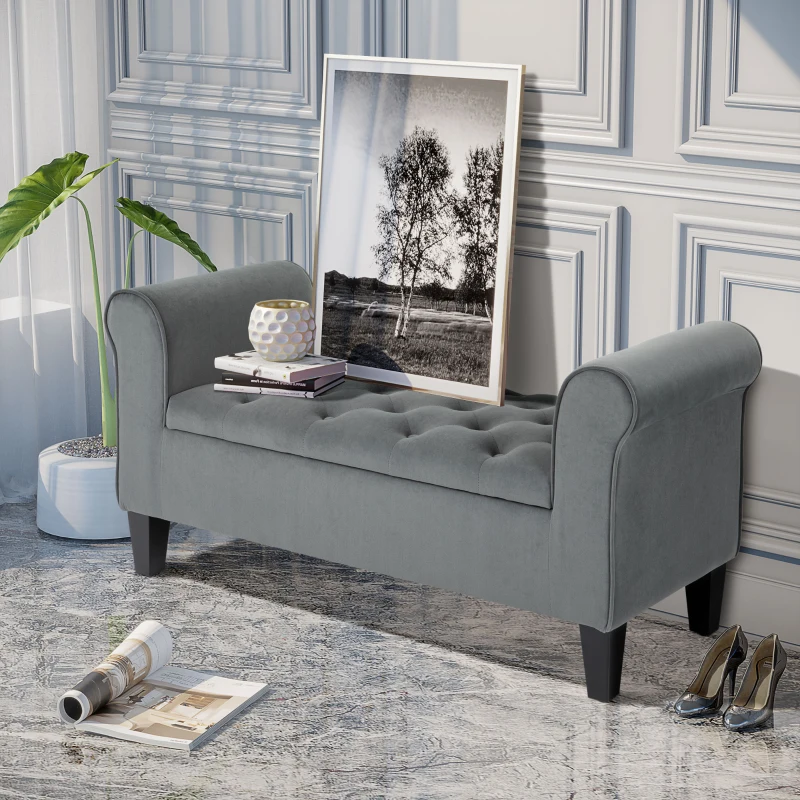 Gray tufted bench with rolled arms and framed art on top.
