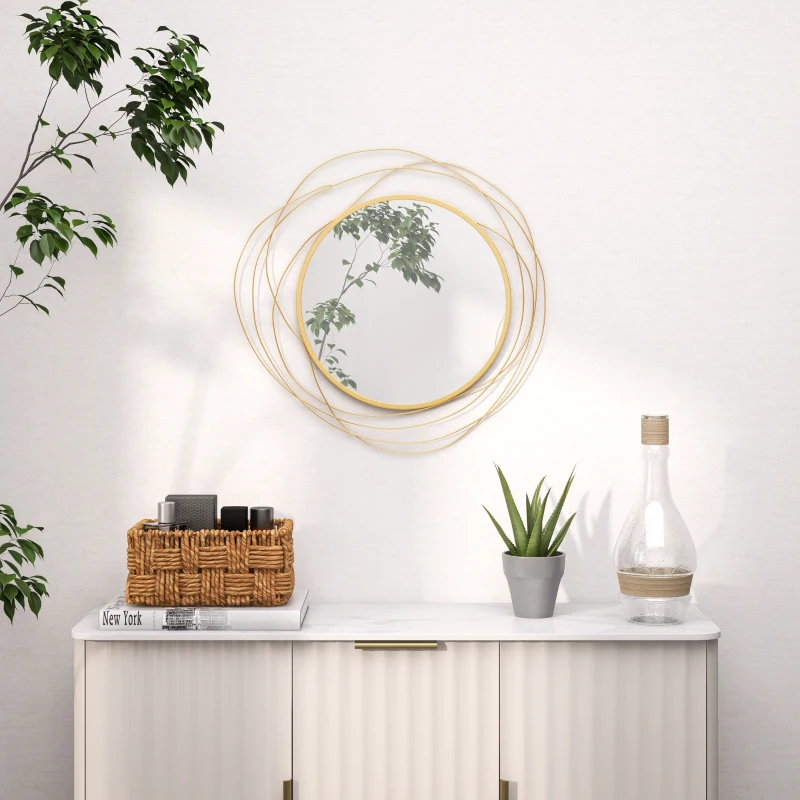 Stylish gold round wall mirror above white cabinet with decor.