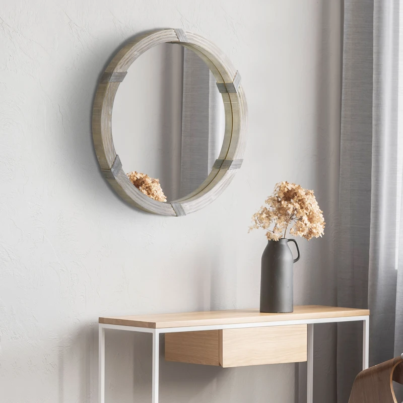 Rustic round wood mirror on light gray wall above table.