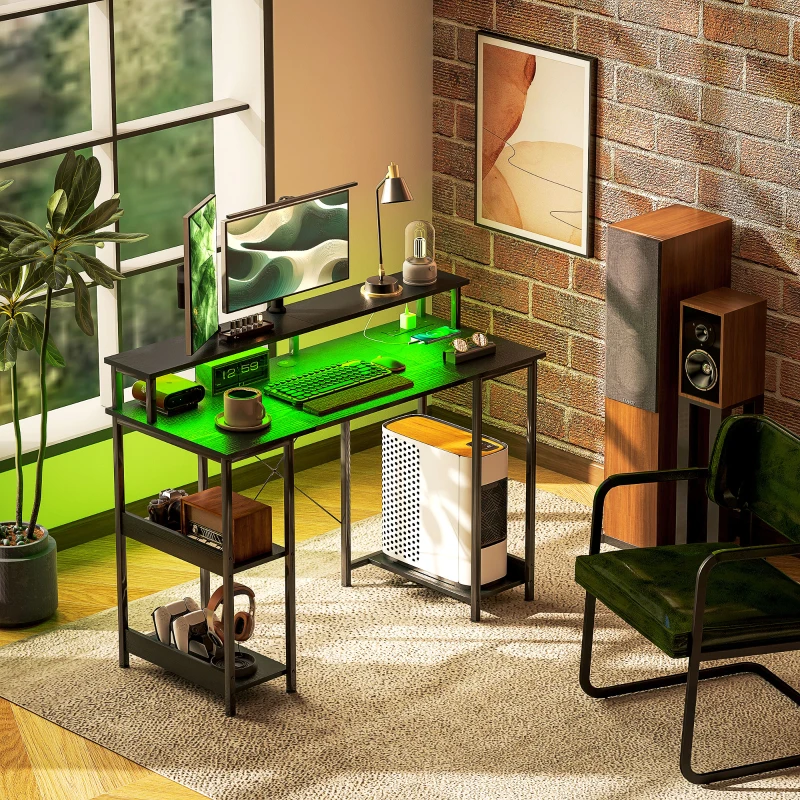 Gaming desk with green LED lighting and monitor setup