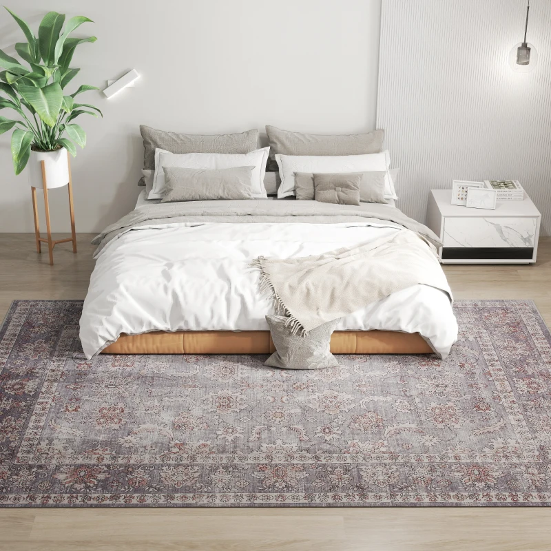 Minimal bedroom with gray-toned vintage rug under white bedding and plants.